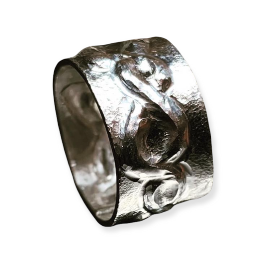Sterling silver repousse ring featuring 3-Dimensional raised interlaced Celtic design. Wide band is suitable for all genders. Textured background, this is a tactile and unqiue ring.
